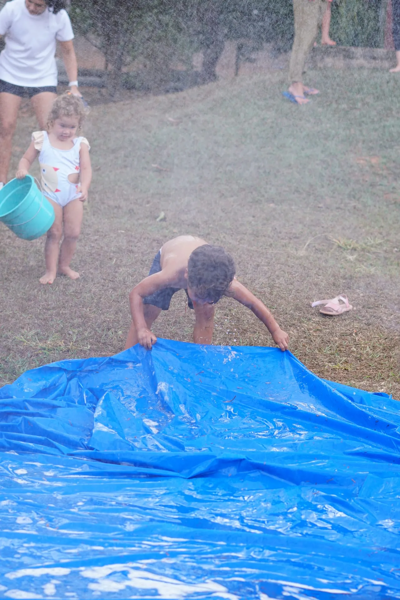 Crianças brincando com água na grama