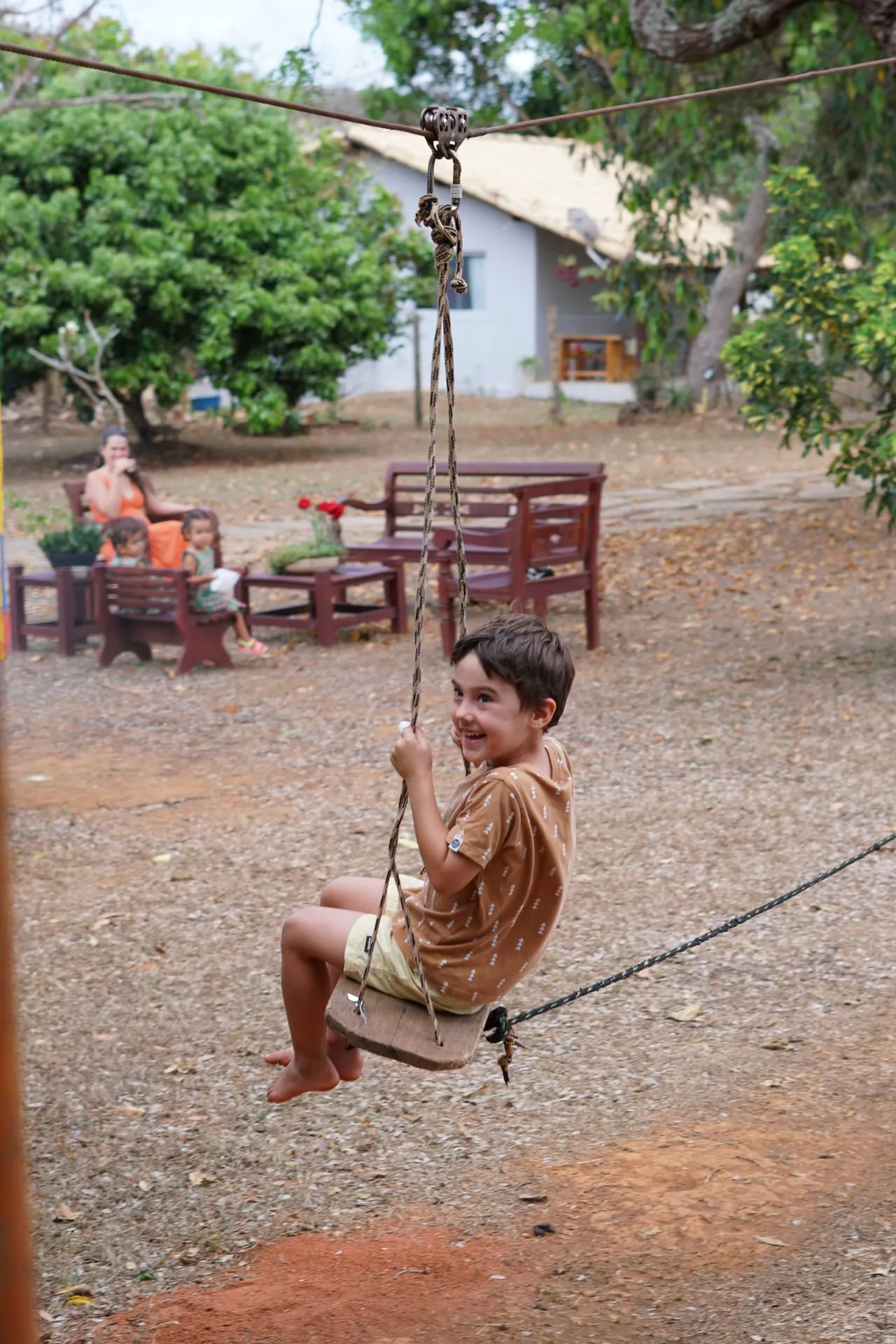 Criança sorrindo no balanço de corda do Oásis