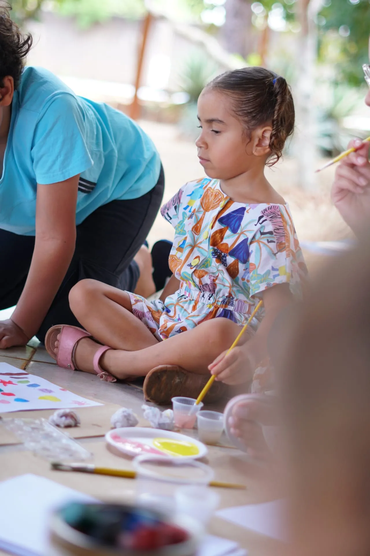 Menina pintando com tinta e pincel